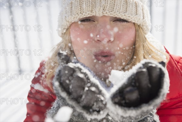 Portrait of woman wearing knit hat blowing snow.
Photo : Jamie Grill