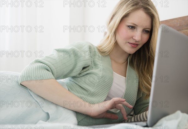 Woman lying in bed and using laptop.
Photo : Jamie Grill