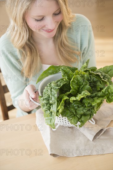 Woman holding colader full with kale.
Photo : Jamie Grill