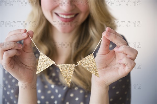 Woman holding small gold banner.
Photo : Jamie Grill