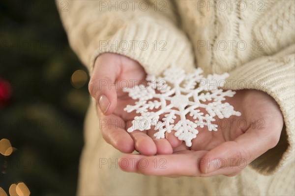 Studio Shot of snowflake on female's hands.
Photo : Jamie Grill