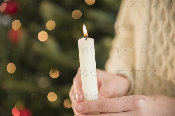 Studio Shot of female's hands holding candle.
Photo : Jamie Grill