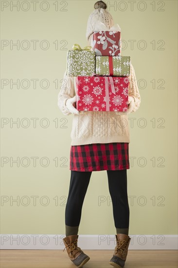 Woman holding stack of presents.
Photo : Jamie Grill