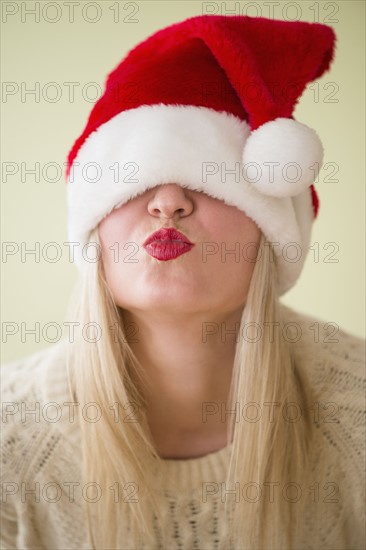 Studio Shot of woman wearing santa hat and puckering.
Photo : Jamie Grill