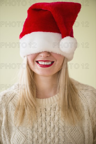 Studio Shot of woman wearing santa hat smiling.
Photo : Jamie Grill
