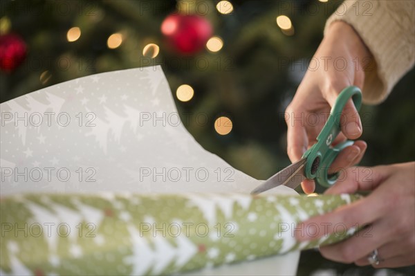 Studio Shot of female's hands cutting wrapping paper.
Photo : Jamie Grill