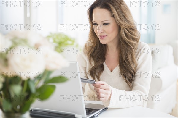 Woman doing online shopping on laptop.
Photo : Jamie Grill