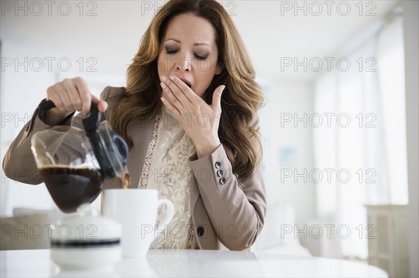 Yawnging woman pouring coffee.
Photo : Jamie Grill