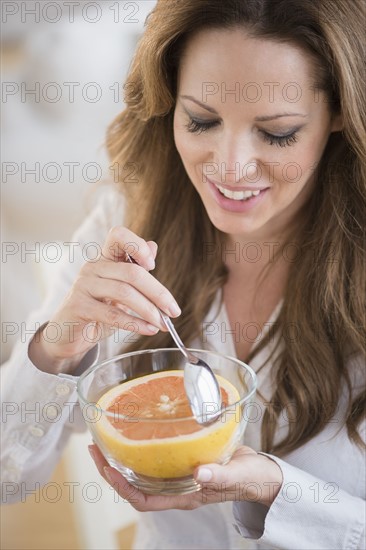 Woman eating grapefruit.
Photo : Jamie Grill