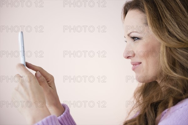 Profile of woman holding digital tablet.
Photo : Jamie Grill