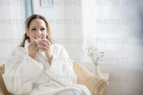 Woman wearing bathrobe drinking tea.
Photo : Jamie Grill