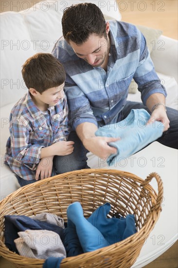 Father sorting laundry with his son (8-9) .
Photo : Jamie Grill
