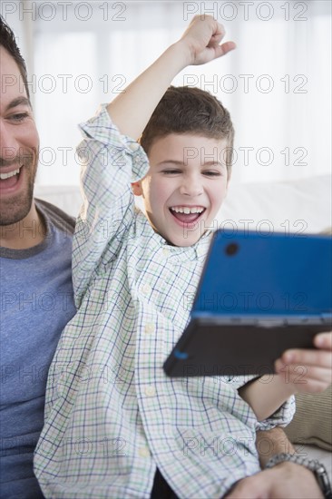 Father and son (8-9) playing video game .
Photo : Jamie Grill