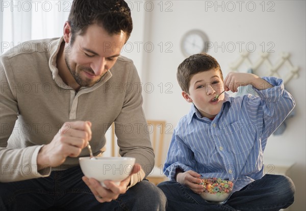 Father and son (8-9) eating breakfast cereal.
Photo : Jamie Grill