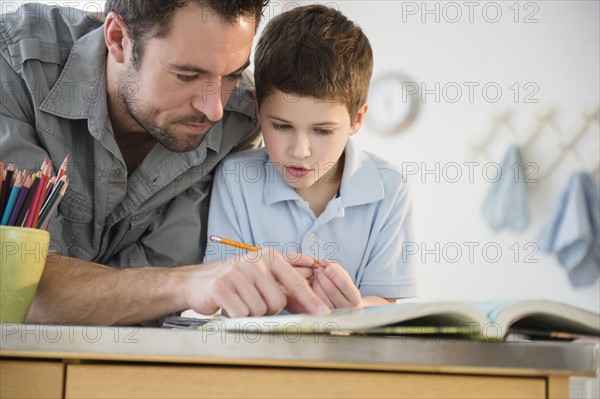 Father helping his son (8-9) with homework.
Photo : Jamie Grill