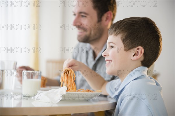 Father and son (8-9) eating spaghetti .
Photo : Jamie Grill