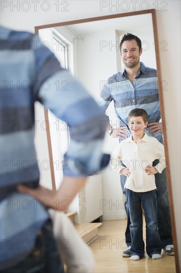 Father and son (8-9) looking at their reflection in mirror.
Photo : Jamie Grill