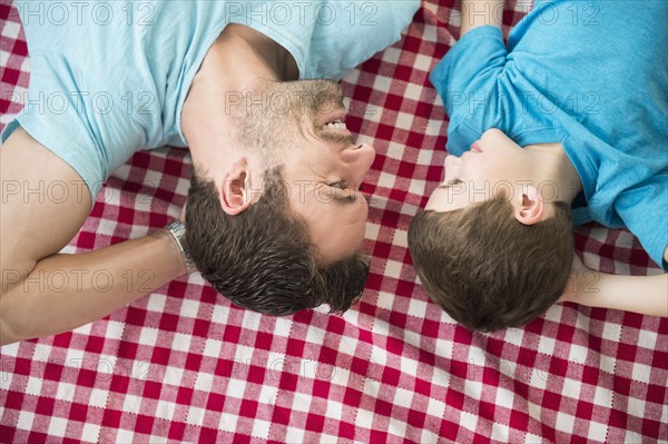 Father and son (8-9) relaxing on checked blanket.
Photo : Jamie Grill