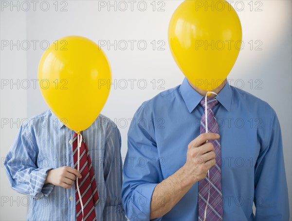 Father and son (8-9) holding yellow balloons.
Photo : Jamie Grill