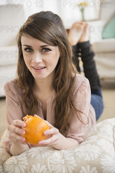 Young woman eating orange .
Photo : Jamie Grill