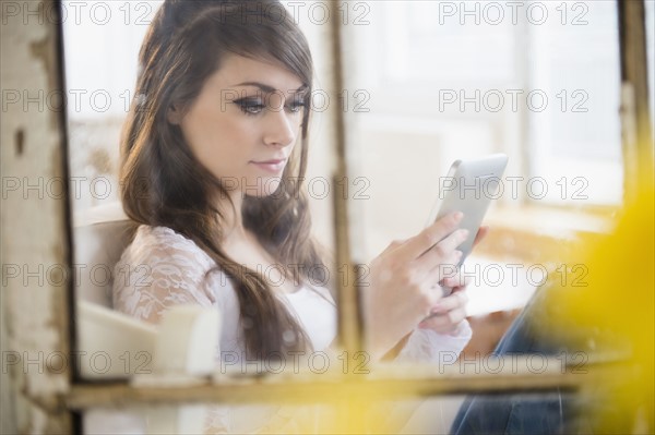 Young woman using digital tablet in living room.
Photo : Jamie Grill