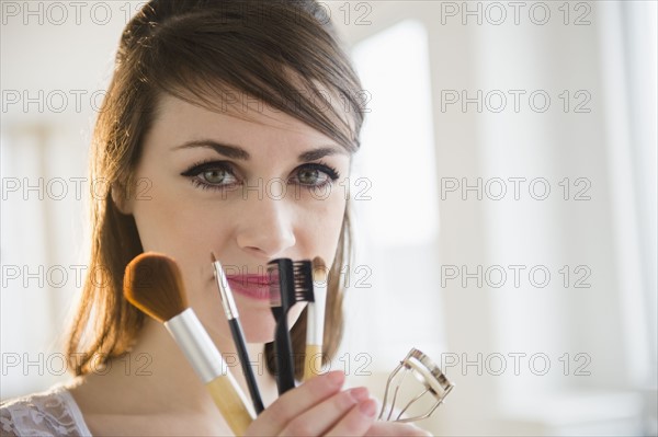 Young woman holding make-up accessories.
Photo : Jamie Grill