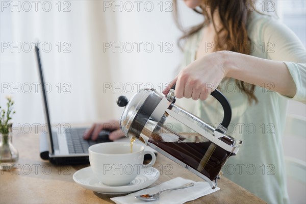 Young woman pouring coffee into cup.
Photo : Jamie Grill