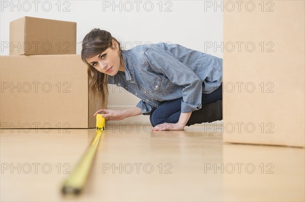 Young woman measuring floor.
Photo : Jamie Grill