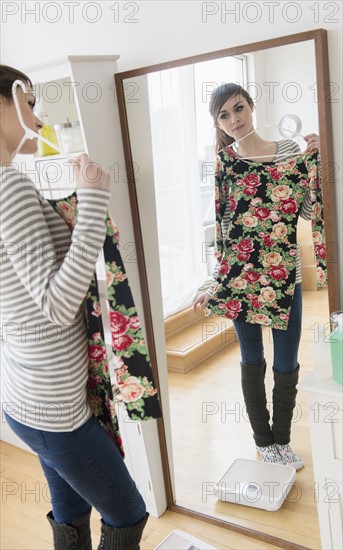 Young woman fitting dress in front of mirror.
Photo : Jamie Grill