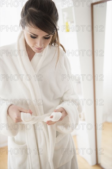 Young woman wearing white bathrobe.
Photo : Jamie Grill