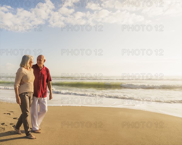 Senior couple walking on beach.
Photo : Daniel Grill
