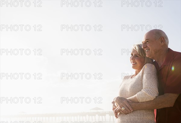 Senior couple embracing on beach.
Photo : Daniel Grill