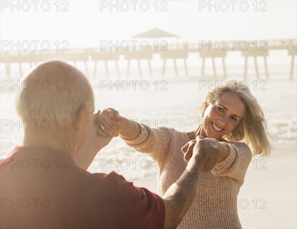 Senior couple dancing on beach.
Photo : Daniel Grill