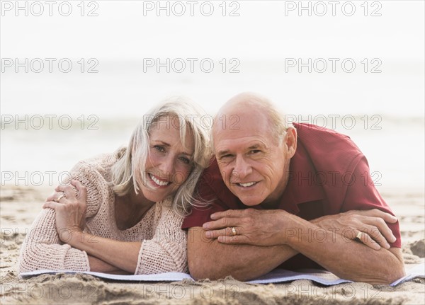 Senior couple lying on beach.
Photo : Daniel Grill