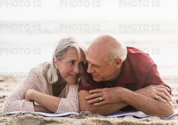 Senior couple lying on beach.
Photo : Daniel Grill