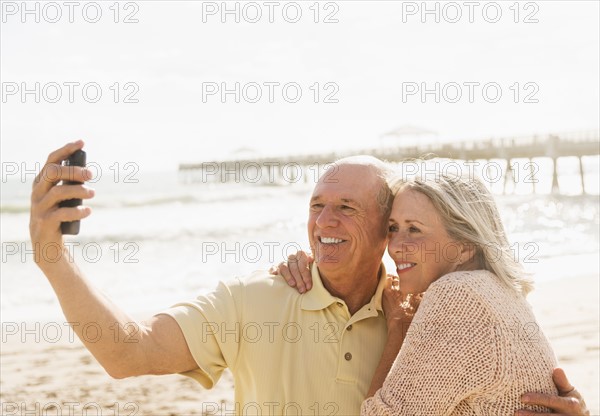 Senior couple taking picture of themselves on beach.
Photo : Daniel Grill