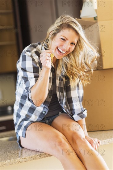 Young woman holding keys of new house.
Photo : Daniel Grill