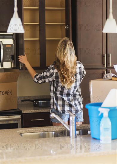 Young woman looking into empty cupboard.
Photo : Daniel Grill