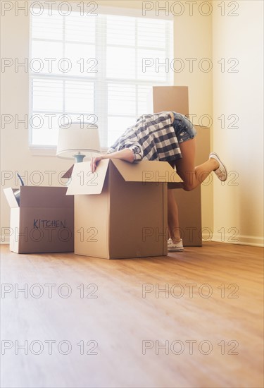 Young woman looking into box in her new house.
Photo : Daniel Grill