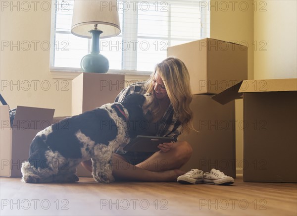 Young woman with dog in their new house.
Photo : Daniel Grill