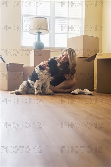 Young woman with dog in their new house.
Photo : Daniel Grill