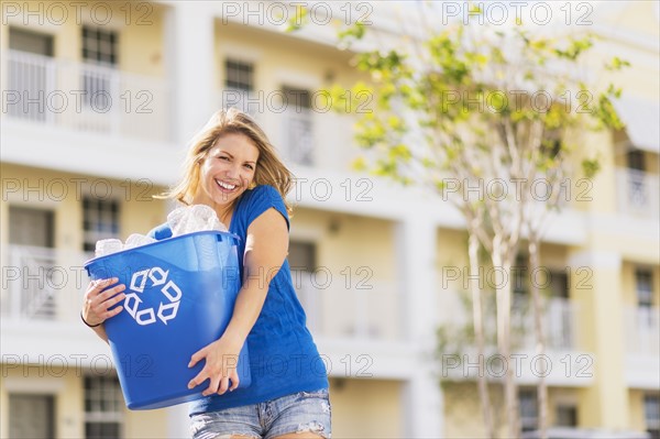 Portrait of woman holding recycling bin.
Photo : Daniel Grill