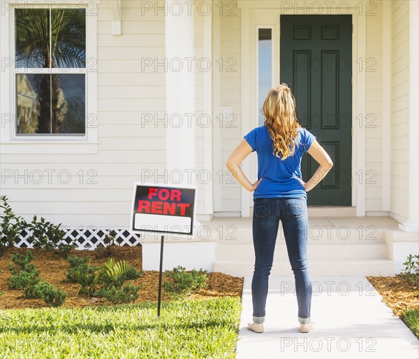 Rear view of woman standing next to for rent sign.
Photo : Daniel Grill