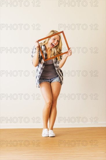 Portrait of woman holding picture frame.
Photo : Daniel Grill