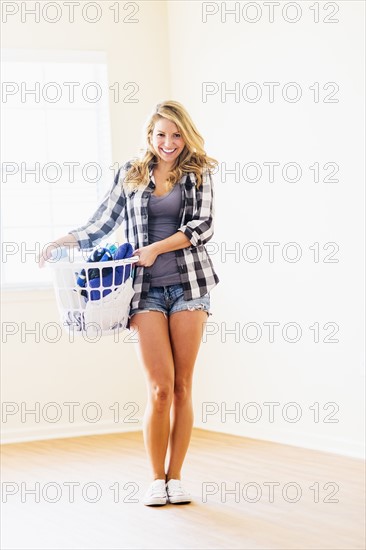 Portrait of woman holding laundry basket.
Photo : Daniel Grill