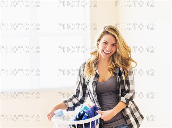 Portrait of woman holding laundry basket.
Photo : Daniel Grill