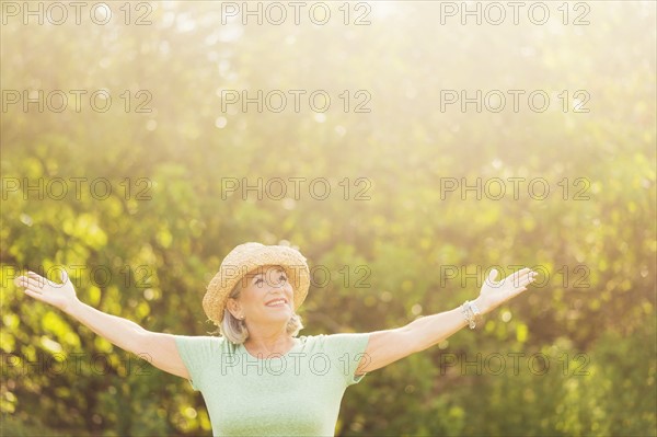 Senior woman in park with arms outstretched.
Photo : Daniel Grill