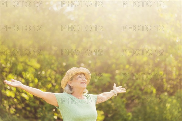 Senior woman in park with arms outstretched.
Photo : Daniel Grill