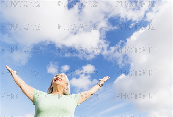 Senior woman with arms outstretched.
Photo : Daniel Grill