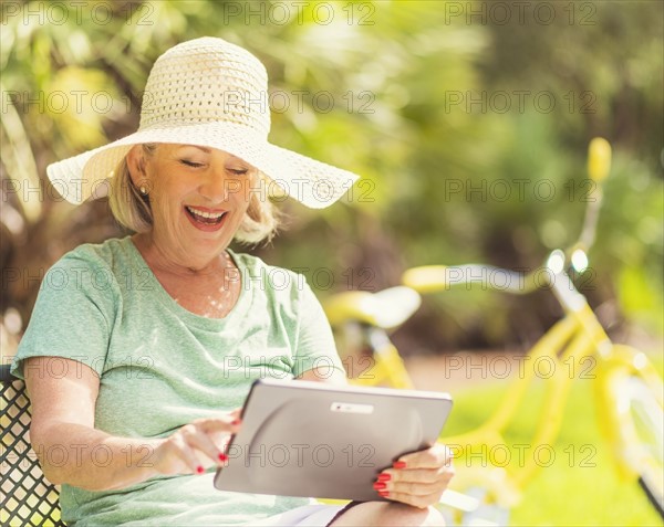 Senior woman using digital tablet in park.
Photo : Daniel Grill